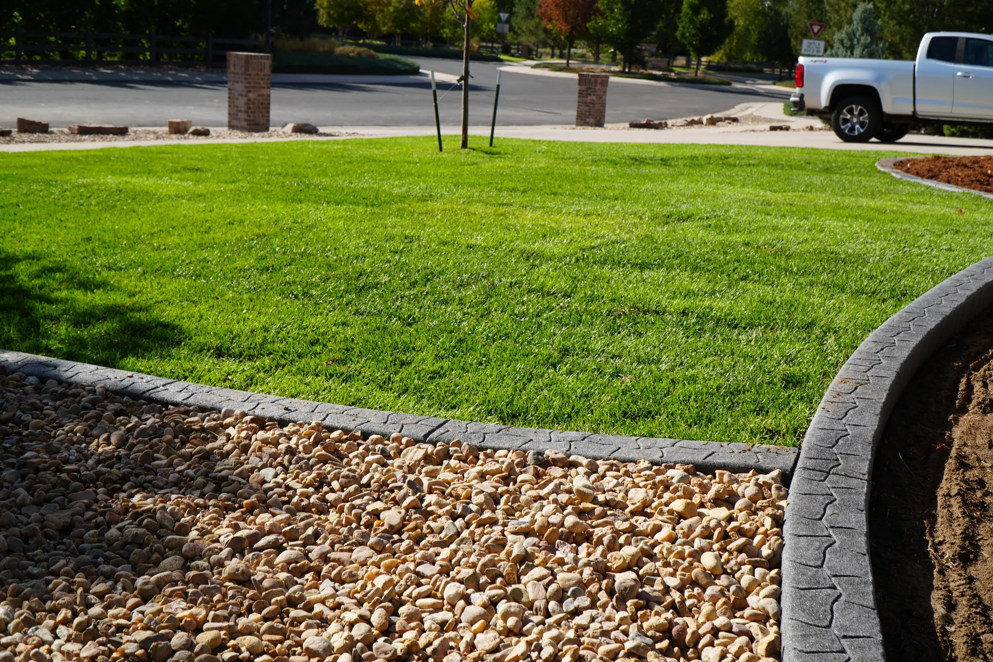 Concrete Curbing: stamped concrete curbing separating the lawn from a rock bed